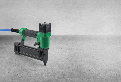 Air nailer tool on an industrial concrete background