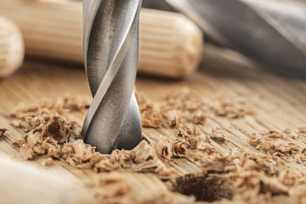 istock drill bit makes hole in wooden oak board for wooden dowel. 1922847310