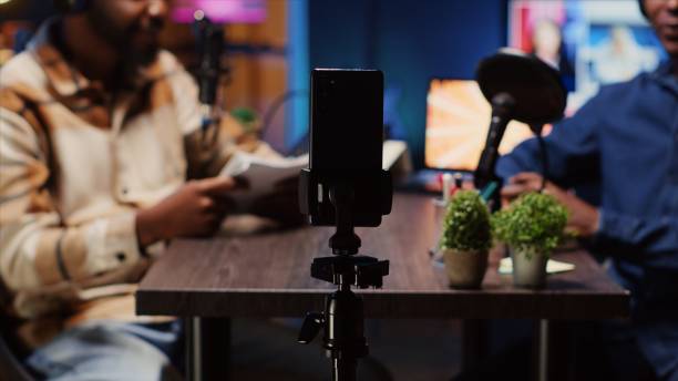 istock Podcast host using smartphone on tripod to record guest telling interesting story 1922885603