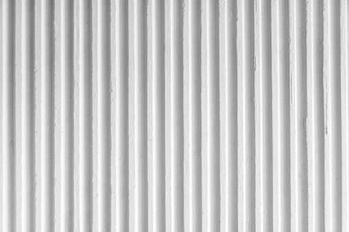 Old white concrete background wall with vertical line ribbed. Stripes as a texture.