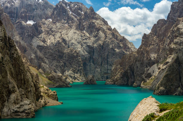 jezero kel-suu, turistické místo na hranicích s čínou, je obklopeno skalnatými útesy, tyrkysovou vodou jezera, zataženou oblohou. - kyrgyzstán - stock snímky, obrázky a fotky