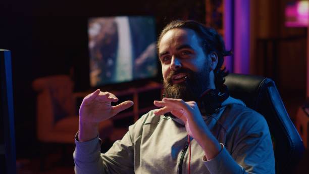 istock Professional gamer streaming multiplayer game while discussing his strategies with fans 1922931166