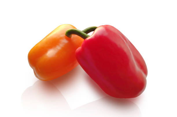 Two peppers, red and yellow, on a white isolated background. isolate