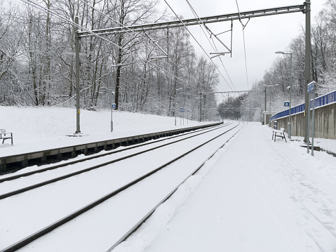 Empty railway and platform covered with white snow