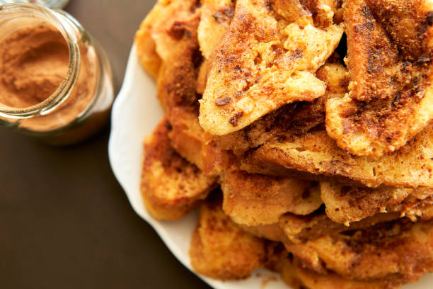 vista superior de una pila de torrijas y un frasco de canela en polvo en la encimera de la cocina - french toast breakfast luxury toast fotografías e imágenes de stock