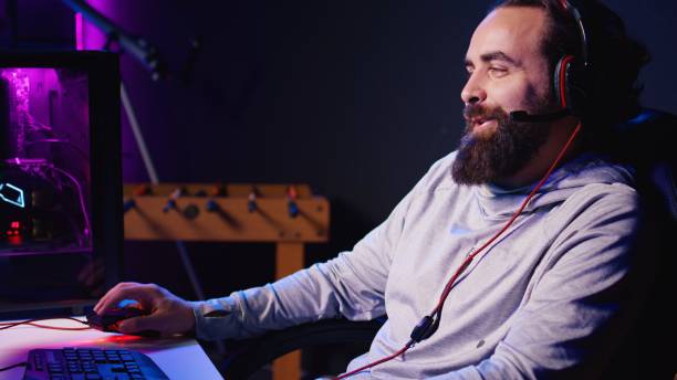 istock Man talking with friends online while playing singleplayer videogame with spaceship shooting laser 1922967969
