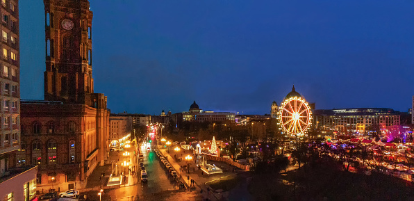 Panorama of evening Berlin  with Christmas tree , Rotes Rathaus and Christmas market (Ferris wheel inside) . Wheel close Berlin Cathedral