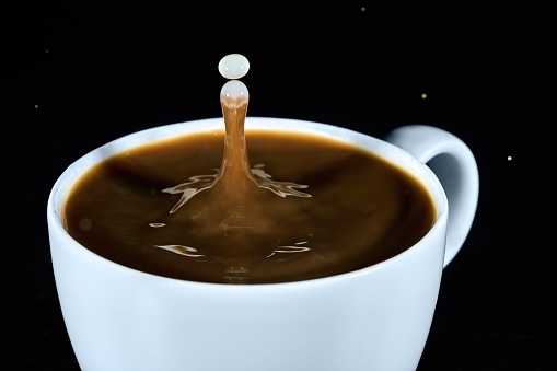 High speed flash shot of milk dripping into coffee