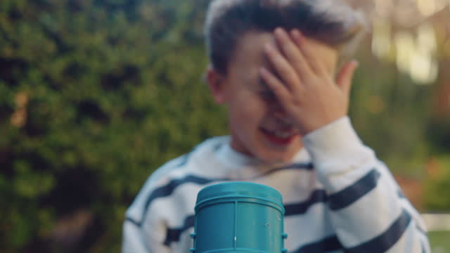 Young boy playing with a leaf blower