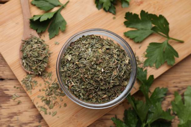 istock Dried parsley and fresh leaves on wooden table, flat lay 1923060879