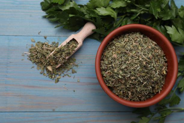 istock Dried parsley and fresh leaves on light blue wooden table, flat lay 1923061414
