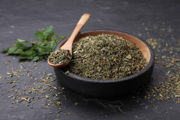 istock Plate and spoon with dried parsley on black table, closeup 1923061830