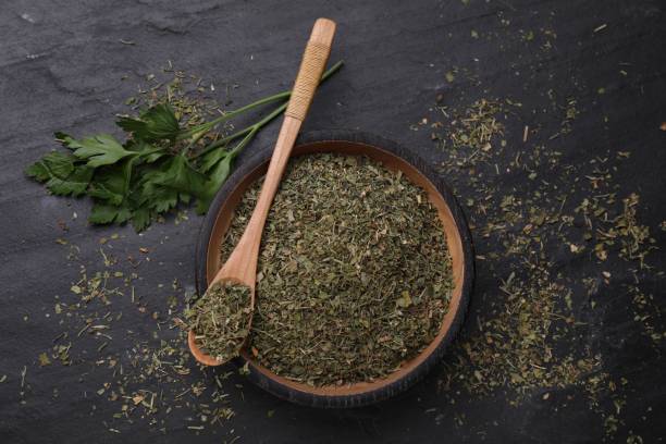 istock Plate and spoon with dried parsley on black table, flat lay 1923061939