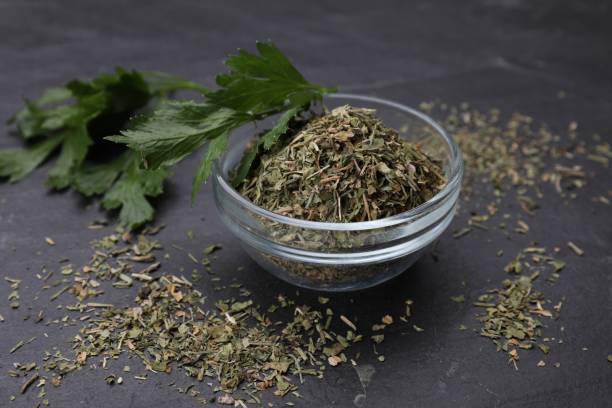 istock Dried parsley and fresh leaves on black table, closeup 1923062484