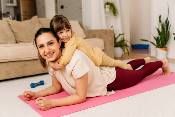 istock Mother and child having fun and smiling  doing exercise on a mat at home 1923066172