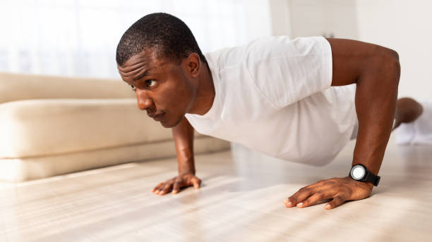 istock Black man exercising in his house gym, doing push ups 1923069984