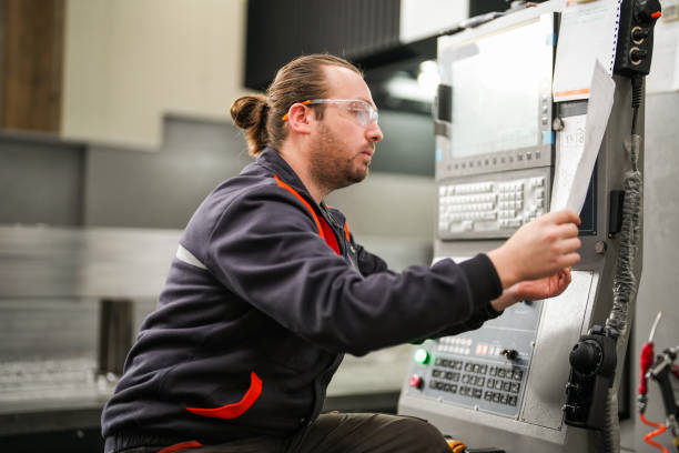 istock Portrait of young technician checking on cnc machine in industry. 1923103007