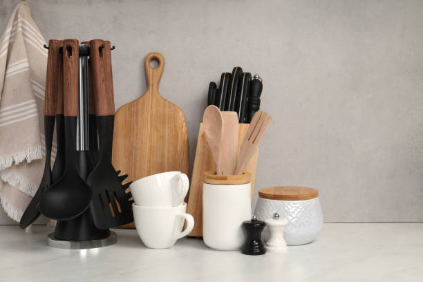 istock Set of different kitchen utensils and cups on white near gray wall 1923119626