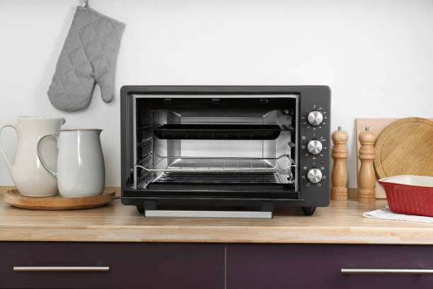 istock Electric oven and kitchen utensils on wooden table indoors 1923121183