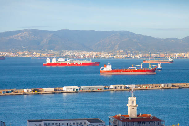Elevated view over the Strait of Gibraltar looking over some empty oil tankers and a breakwater to the Spanish industrial and port town of Algeciras.