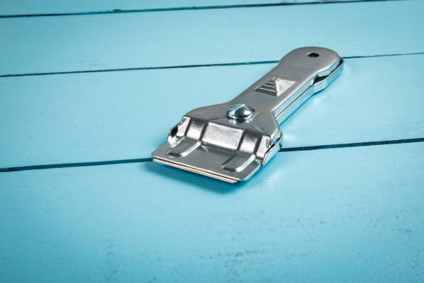 istock Glass ceramic scraper on a blue wooden texture background 1923216921