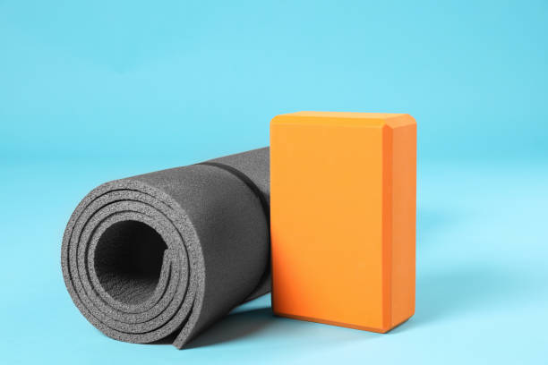 istock Exercise mat and yoga block on light blue background 1923264058