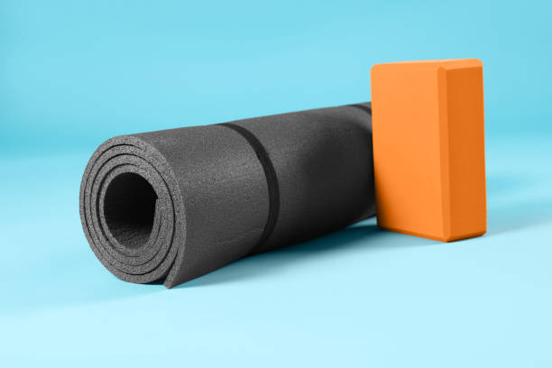 istock Exercise mat and yoga block on light blue background 1923264580