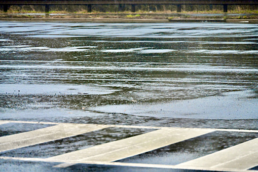 Water pools in an intersection after running downhill during a torrential rain storm.