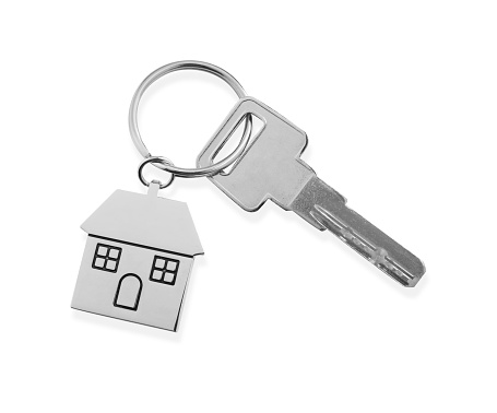 Key with metallic keychain in shape of house isolated on white, top view