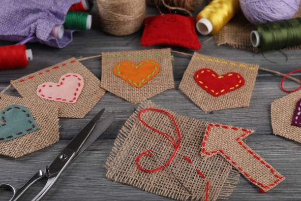 istock Bunting flags made with burlap fabric and sewing tools on wooden table, closeup 1923290520