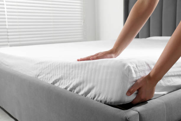 istock Woman touching soft mattress indoors, closeup view 1923299828