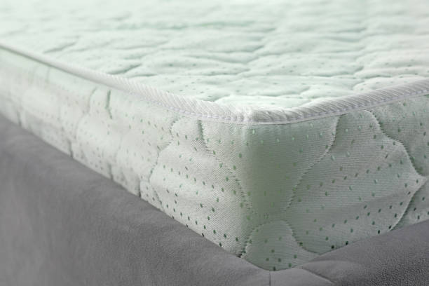 istock New light green mattress on gray bed, closeup 1923304525