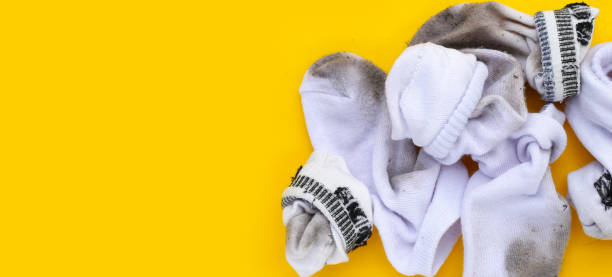 istock Dirty white socks on yellow background. 1923306012