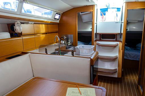 An image capturing the cozy and well-appointed interior of a sailing boat in the British Virgin Islands, showcasing the perfect blend of comfort and nautical charm. The space is designed for both functionality and relaxation, providing an intimate setting for experiencing the serene beauty of the Caribbean seas.