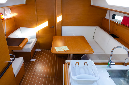 An image capturing the cozy and well-appointed interior of a sailing boat in the British Virgin Islands, showcasing the perfect blend of comfort and nautical charm. The space is designed for both functionality and relaxation, providing an intimate setting for experiencing the serene beauty of the Caribbean seas.
