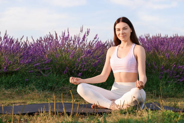 istock Beautiful woman practicing yoga near blooming lavender outdoors. Space for text 1923333165