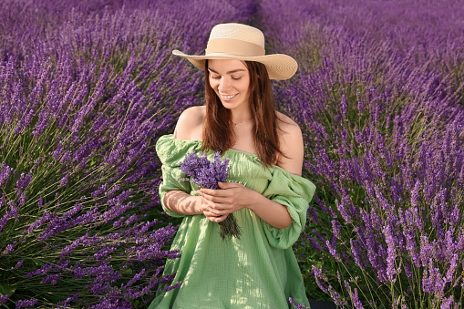 Smiling woman with bouquet in lavender field