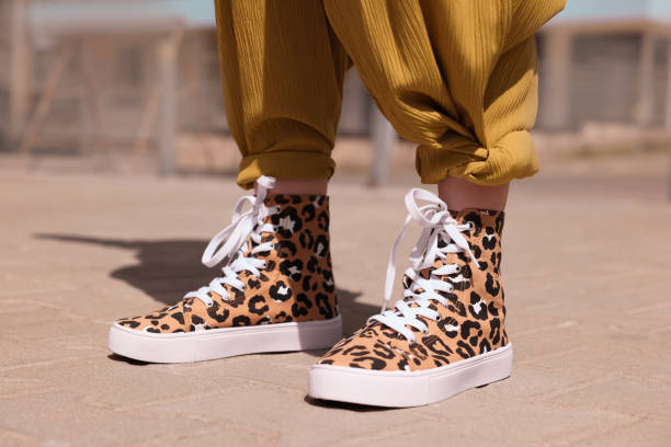 istock Woman wearing sneakers with leopard print outdoors, closeup 1923335317