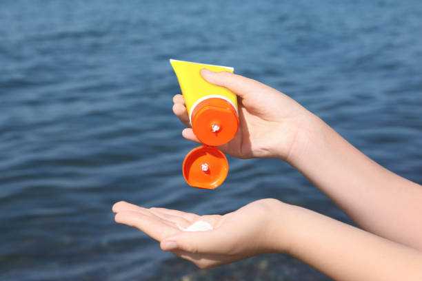 istock Woman applying sunscreen outdoors, closeup. Sun protection care 1923337982