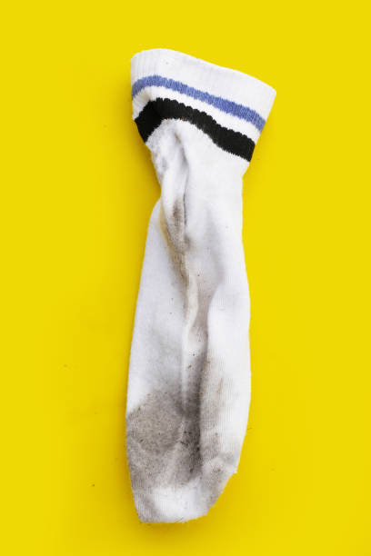 istock Dirty white socks on yellow background. 1923339029