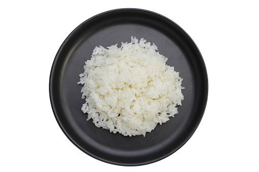 Cooked rice in black plate on dark background.