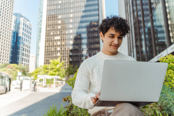 istock Successful young hispanic businessman working on computer, using laptop on urban street 1923378735
