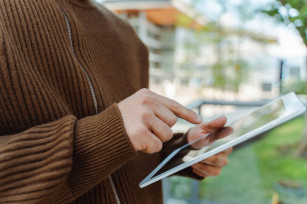 istock Young man holding digital tablet selective focus. Businessman working online at workplace 1923378775