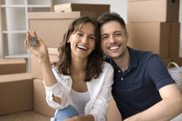 istock Happy attractive young couple sitting among cardboard moving boxes 1923392882