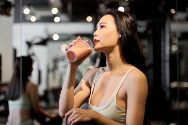 istock Female trainee drinking protein at the gym 1923420295