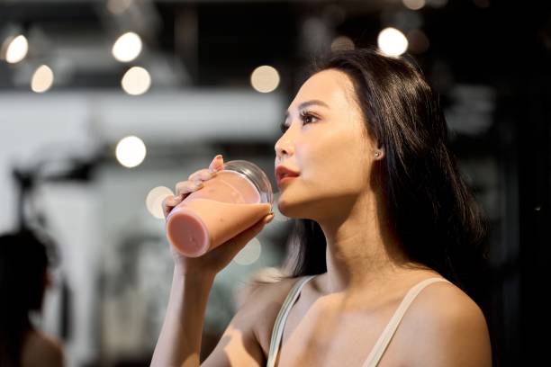 istock Female trainee drinking protein at the gym 1923420296