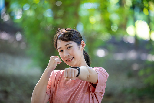 Portrait of female athlete in nature - punching pose