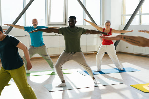 istock Group of senior athletes raise hands to ceiling at workout 1923491467