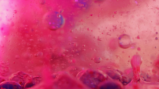 Gel fluid splash. Paint bubble. Serum emulsion texture. Defocused vivid pink blue color translucent wet ink droplet floating motion art abstract background.