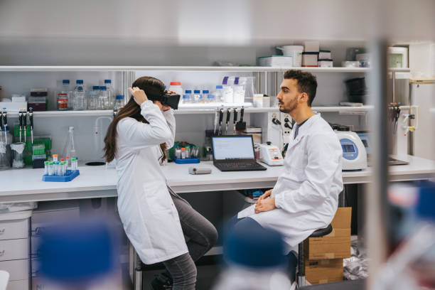 Two scientists engage in testing VR glasses and integrated technology, exchanging observations and fine-tuning settings